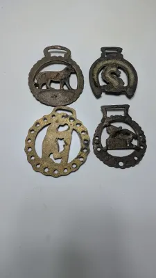 Sale Photo Thumbnail #298: Horse brass bridal medallions (or "horse brasses") are decorative, solid-brass plaques originally used to embellish the bridles and harnesses of working and parade horses. Originating in England in the mid-19th century, carters and farmers first used them