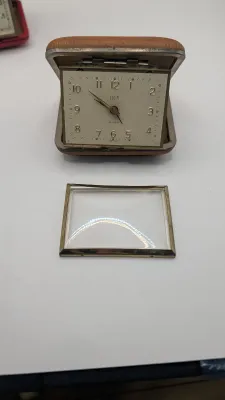 Sale Photo Thumbnail #405: Clocks are untested - The Elgin face cover has come off

Bradley and Elgin are classic mid-20th-century folding travel and desk alarm clocks manufactured in (West) Germany, typically featuring mechanical wind-up, 1-jewel movements. Often utilized by vario