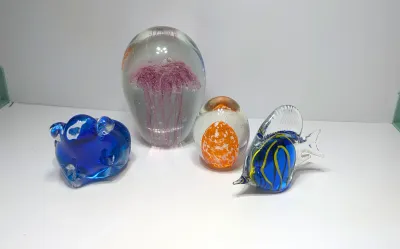 Sale Photo Thumbnail #336: None of the paperweights are signed.  Paperweights have surface starches on the bottom


Art glass paperweights are highly collectible, functional sculptures prized for their internal complexity, vivid colors, and technical craftsmanship. Originating as a