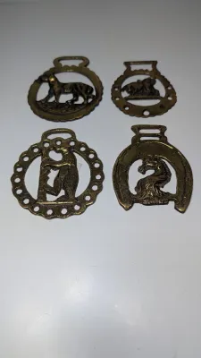 Sale Photo Thumbnail #292: Horse brass bridal medallions (or "horse brasses") are decorative, solid-brass plaques originally used to embellish the bridles and harnesses of working and parade horses. Originating in England in the mid-19th century, carters and farmers first used them