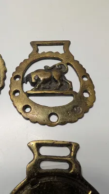 Sale Photo Thumbnail #293: Horse brass bridal medallions (or "horse brasses") are decorative, solid-brass plaques originally used to embellish the bridles and harnesses of working and parade horses. Originating in England in the mid-19th century, carters and farmers first used them