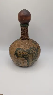 Sale Photo Thumbnail #20: Vintage 1960s leather-wrapped world map bottles are iconic mid-century barware collectibles. Most were handcrafted in Italy (particularly Florence) as decorative decanters for wine or liquor

Materials: Green or brown glass bottles encased in genuine, hea