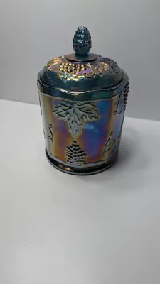 Sale Photo Thumbnail #273: This item is an original "Harvest Grape" (or simply "Harvest") pattern covered canister manufactured by the Indiana Glass Company.

Distinctive embossed clusters of grapes and large leaves, complete with a matching lid and textured finial.the pattern was 