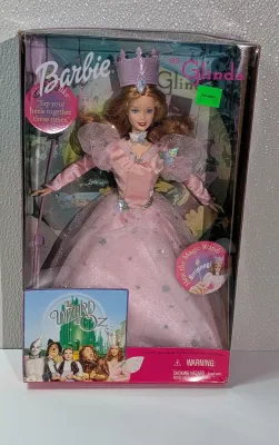 Sale Photo Thumbnail #360: A highly popular playline doll. When you raise her arm, she plays a "brrinnng" magic wand sound effect or says, "Tap your heels together three times". She features strawberry-blonde hair and a pink satin gown with star and butterfly accents