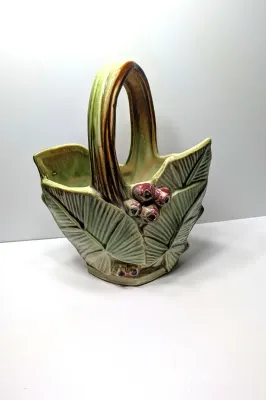 Sale Photo Thumbnail #261: The Vintage McCoy 1940s Leaves & Berries basket planter/vase is a highly collectible piece of American art pottery. Typically featuring a textured, woven-look basket with embossed botanical leaves and painted berries, these pieces are highly prized for th