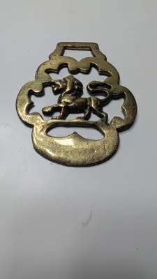 Sale Photo Thumbnail #306: Horse brass bridal medallions (or "horse brasses") are decorative, solid-brass plaques originally used to embellish the bridles and harnesses of working and parade horses. Originating in England in the mid-19th century, carters and farmers first used them