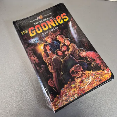 LOT 27B: Vintage VHS Clamshell Collection with Sealed "The Goonies" Movie