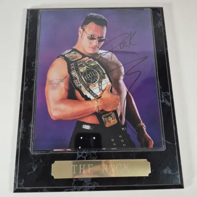 LOT 192Z: Stone Cold & The Rock Autographed Plaques, 1999 WWF WrestleMania T-Shirt & More