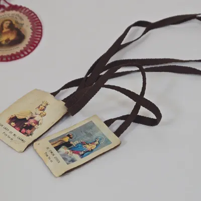 LOT 52: Statue Depicting the Infant Jesus of Prague, Multiple Scapulars, Italian-made Crucifix Pendant, and More