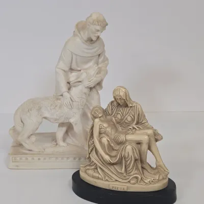 LOT 51: White Devotional Statue of Saint Francis of Assisi Taming the Wolf of Gubbio and Replica Figurine of Michelangelo's Pietà,...