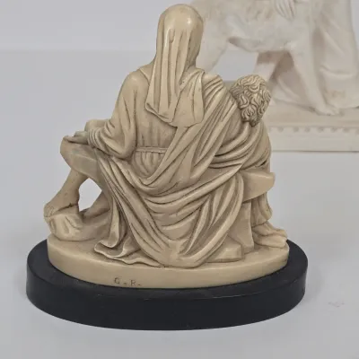 LOT 51: White Devotional Statue of Saint Francis of Assisi Taming the Wolf of Gubbio and Replica Figurine of Michelangelo's Pietà,...
