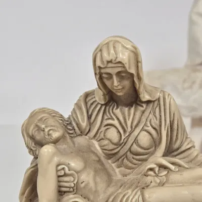 LOT 51: White Devotional Statue of Saint Francis of Assisi Taming the Wolf of Gubbio and Replica Figurine of Michelangelo's Pietà,...