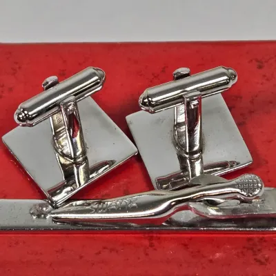 LOT 54: Swank Tie Pin with Matching Cufflinks, Vintage Caravelle Wristwatch, Socony Gas 5 Year Pin, Gold-tone WWII Honorable Discharge...