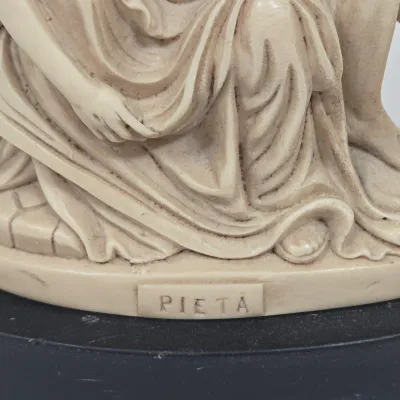 LOT 51: White Devotional Statue of Saint Francis of Assisi Taming the Wolf of Gubbio and Replica Figurine of Michelangelo's Pietà,...