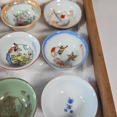 LOT 132F: Large Collection of Antique Japanese Military Sake Cups, Four Sake Bottles, and Beautiful Wood Chest for Storage