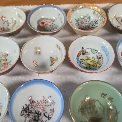 LOT 132F: Large Collection of Antique Japanese Military Sake Cups, Four Sake Bottles, and Beautiful Wood Chest for Storage
