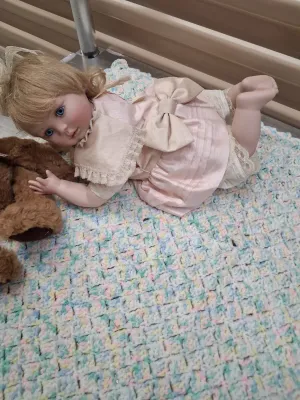 Sale Photo Thumbnail #478: PORCELAIN BABY DOLL IN PINK DRESS, RUSS BERRIE LANGLEY TEDDY BEAR, DEPARTMENT 50 TED D. BEAR PLUSH, ADDITIONAL TEDDY BEAR, AND CROCHETED BABY BLANKET. ALL ITEMS ARE IN PRE-OWNED CONDITION WITH NO VISIBLE MAJOR DAMAGE.