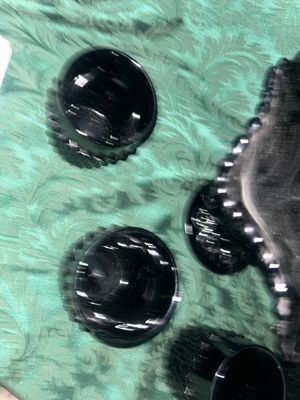 Sale Photo Thumbnail #629: VINTAGE BLACK AMETHYST GLASS COMPOTE PEDESTAL BOWL WITH FOUR MATCHING HOBNAIL/DIAMOND POINT TUMBLERS. FEATURES A TEXTURED GEOMETRIC PATTERN AND STARBURST BASE DETAILS. LIGHT WEAR FROM USE, NO VISIBLE CHIPS OR CRACKS.
