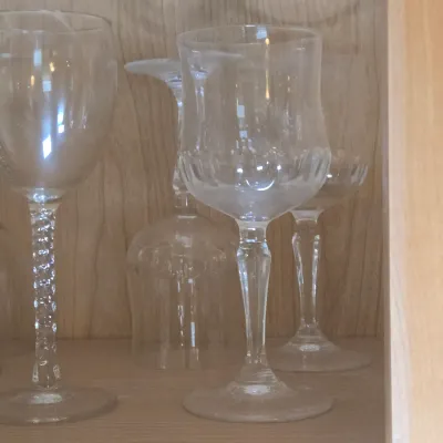 LOT 101: Kitchen Cabinet Lot Including Wine Glasses, Trifle Bowl, and More