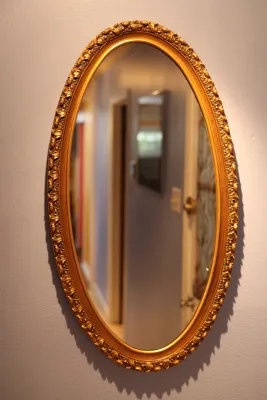 Ornate Gold Framed Oval Wall Mirror with Floral Scroll Detail