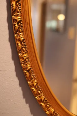 Ornate Gold Framed Oval Wall Mirror with Floral Scroll Detail