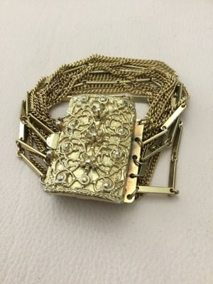 Vintage multi strand, gold tone bracelet, featuring intricate open work, rectangular, sliding centerpiece, class decorated with raised...