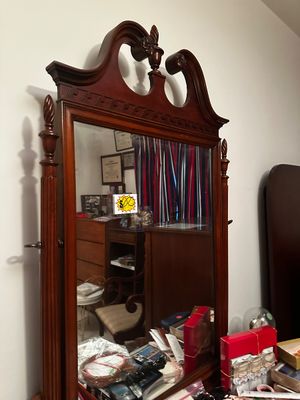 Sale Photo Thumbnail #48: Mahogany wood with a dark reddish-brown finishFeatures: Seven total drawers (three on each side and one center drawer), brass-toned hardware pulls, scrolled pediment on the mirror, and a matching stool with dark upholstery