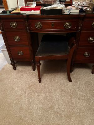 Sale Photo Thumbnail #47: Mahogany wood with a dark reddish-brown finishFeatures: Seven total drawers (three on each side and one center drawer), brass-toned hardware pulls, scrolled pediment on the mirror, and a matching stool with dark upholstery