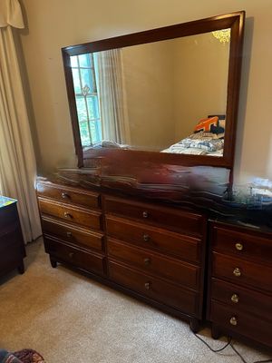 Sale Photo Thumbnail #43: traditional dark wood triple dresser paired with a large matching rectangular wall mirror featuring simple round drawer pulls.