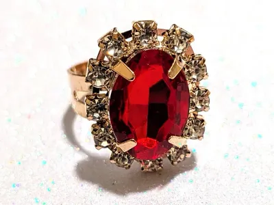 **NEW ARRIVAL** Size 7¼ RED OVAL GLASS STONE RING with 12 Jeweled Clear Stones Surround 4-Pong on an ADJUSTABLE SPLIT BAND on a Gold Tone...