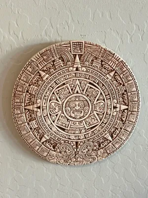 Circular Aztec sun stone calendar wall plaque.