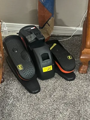 Cubii under-desk elliptical trainer in black and orange, designed for low-impact seated exercise.