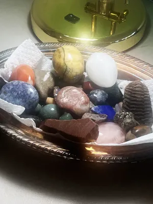Assorted collection of polished and raw gemstones, minerals, and carved stone eggs.