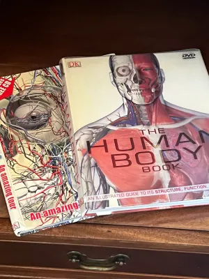 Two DK illustrated reference books about human anatomy, including "The Human Body Book" with its accompanying DVD-ROM.