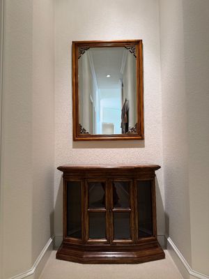 WOODEN LIGHTED LOW CABINET WITH MULTI-PANE GLASS DOUBLE DOORS AND A BEAUTIFUL RECTANGULAR WOOD FRAMED WALL MIRROR ACCENTED WITH ORNATE...