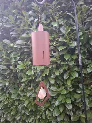 U.S. Expedition wind bell with a copper-tone finish, featuring a triangular wind catcher and a polished agate slice accent.