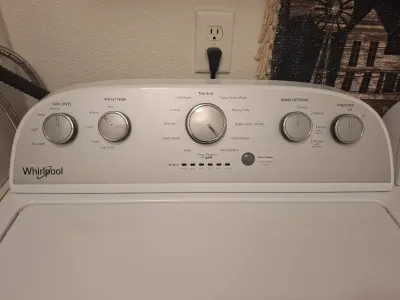Whirlpool top-load washing machine control panel, featuring multiple dial settings for soil level, wash temp, cycle selection, rinse...