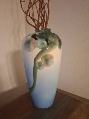 Franz Porcelain 'Frog on Lotus' vase featuring a sculpted frog and lily pads in relief against a blue and white gradient...