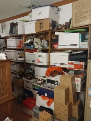 A collection of wooden shelving units filled with various storage boxes, office supplies, and household items.
