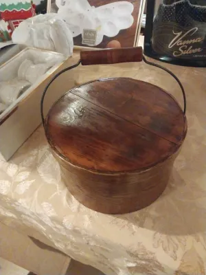 Vintage round wooden firkin or sugar bucket with a wire bail handle and wooden grip.
