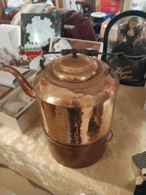 Vintage copper tea kettle with a matching warming stand, featuring a dark wooden handle and lid knob.