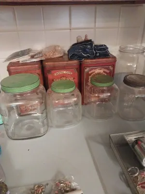 Collection of vintage kitchen storage containers, including three clear glass jars with green metal lids and three red metal canisters...
