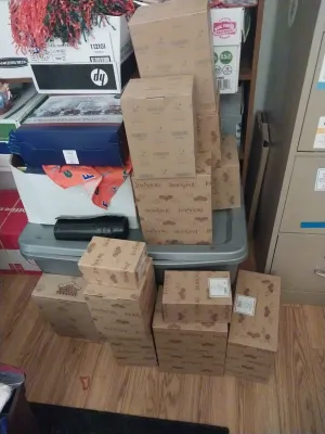 Collection of boxed Jim Shore figurines and collectibles stacked on a plastic storage bin and the floor.