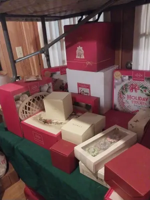 Collection of boxed Lenox holiday tableware and decorative items, including a "Holiday Treats" plate and various gift boxes.