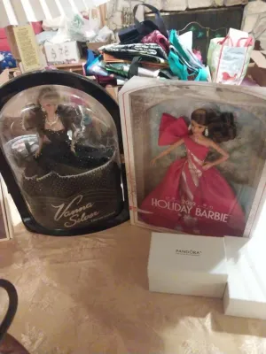 Two collector dolls in their original packaging, featuring a Vanna Silver Limited Edition doll and a 2019 Holiday Barbie in a pink gown,...