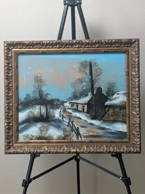 Framed oil painting depicting a snowy winter landscape in Holland, featuring a rustic cottage and path, housed in an ornate gold-finished...