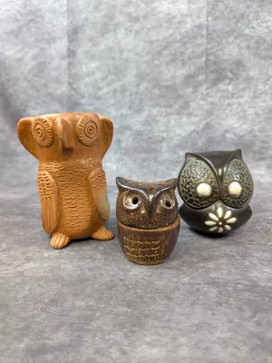Trio of vintage ceramic owl figurines, including a tall unglazed terracotta owl, a small brown glazed owl shaker, and a dark brown studio...