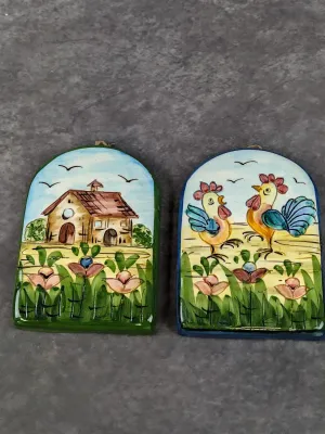 Pair of vintage hand-painted ceramic arched wall plaques featuring folk art countryside scenes with a barn and roosters.