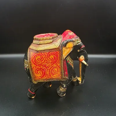 Hand-painted Indian style carved wooden elephant figurine featuring ornate red and gold floral blanket details.