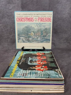 Vintage record collection featuring a Longines Symphonette 'Christmas at the Fireside' vinyl box set displayed above a stack of...